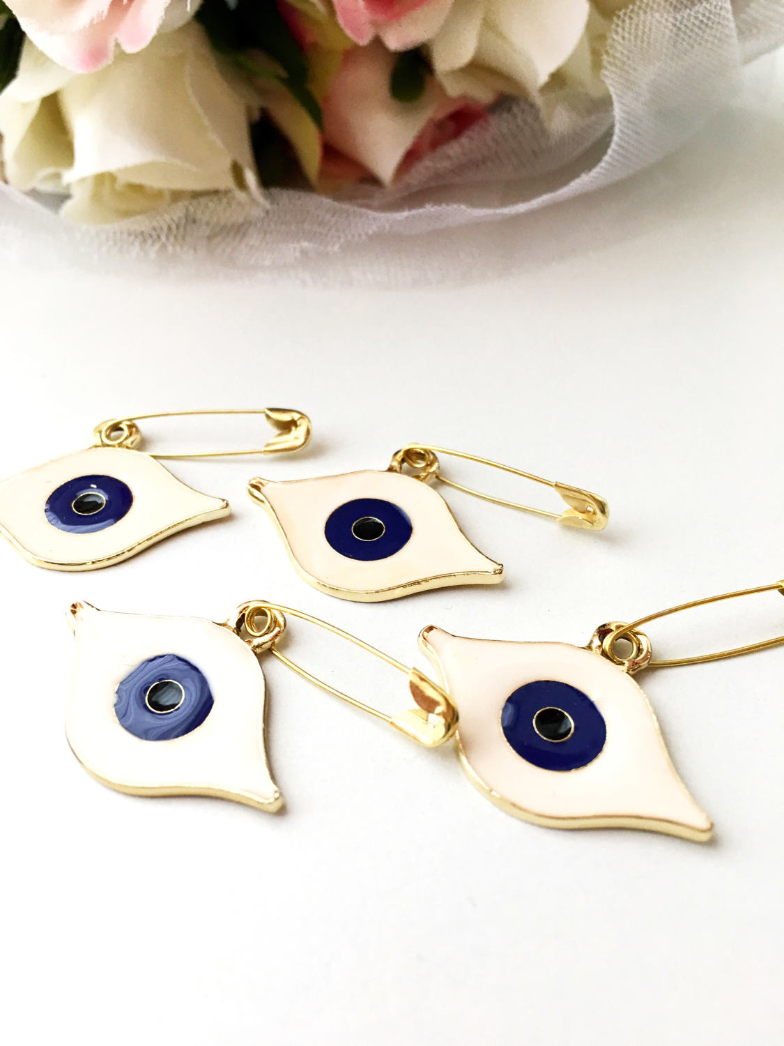 Gold plated evil eye safety pin with big enamel eye design, symbolizing protection and charm.