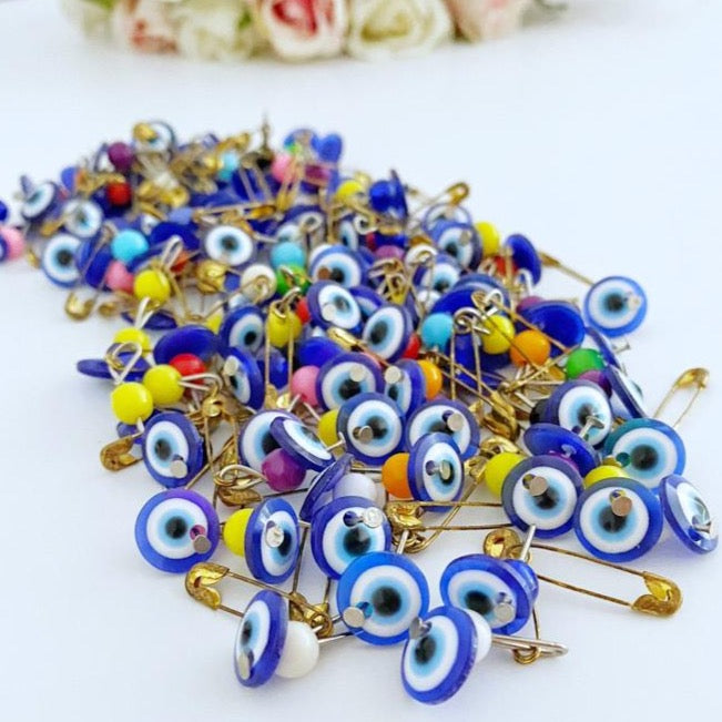 A collection of 100 blue evil eye safety pins, featuring resin beads and gold plating, perfect for weddings and baby showers.