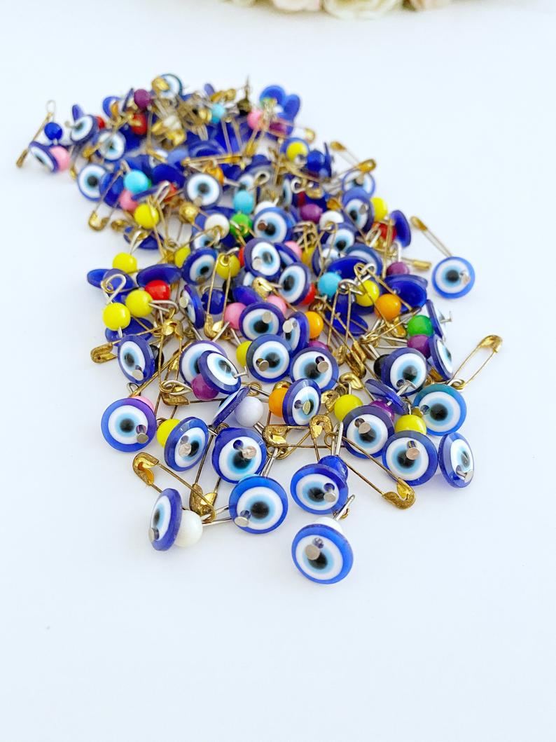 A collection of 100 blue evil eye safety pins, featuring resin beads and gold plating, perfect for weddings and baby showers.