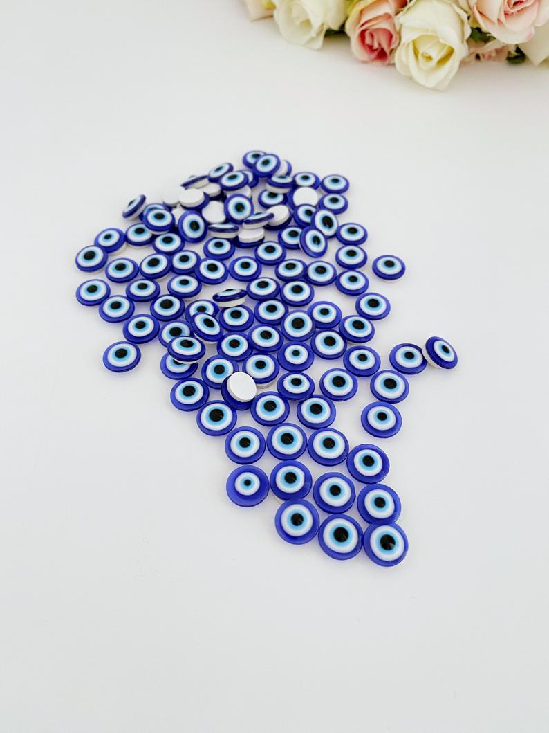 A collection of 100 colorful resin evil eye stickers, each measuring 10mm, showcasing intricate designs for protection and decoration.