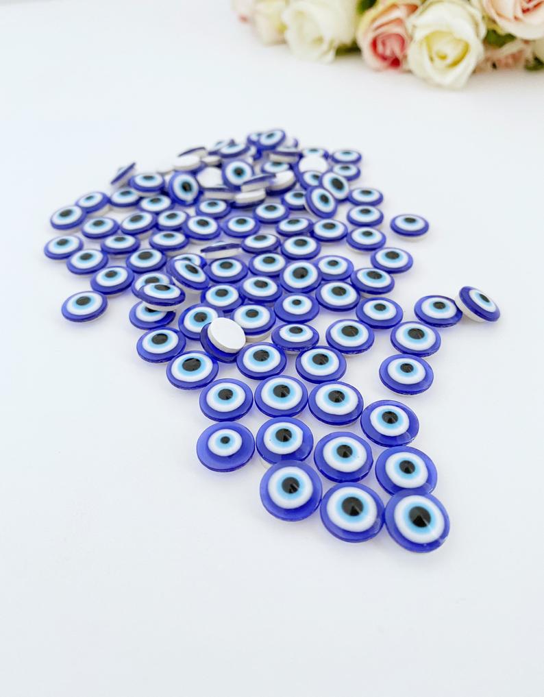 A collection of 100 colorful resin evil eye stickers, each measuring 10mm, showcasing intricate designs for protection and decoration.