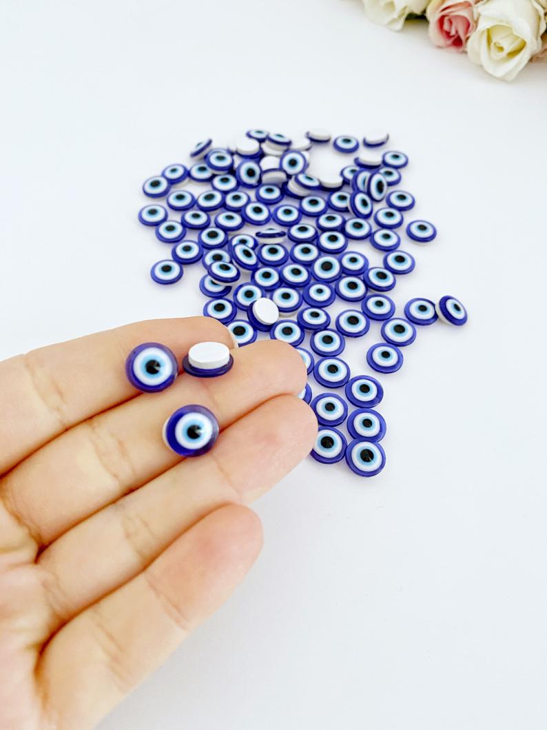 A collection of 100 colorful resin evil eye stickers, each measuring 10mm, showcasing intricate designs for protection and decoration.