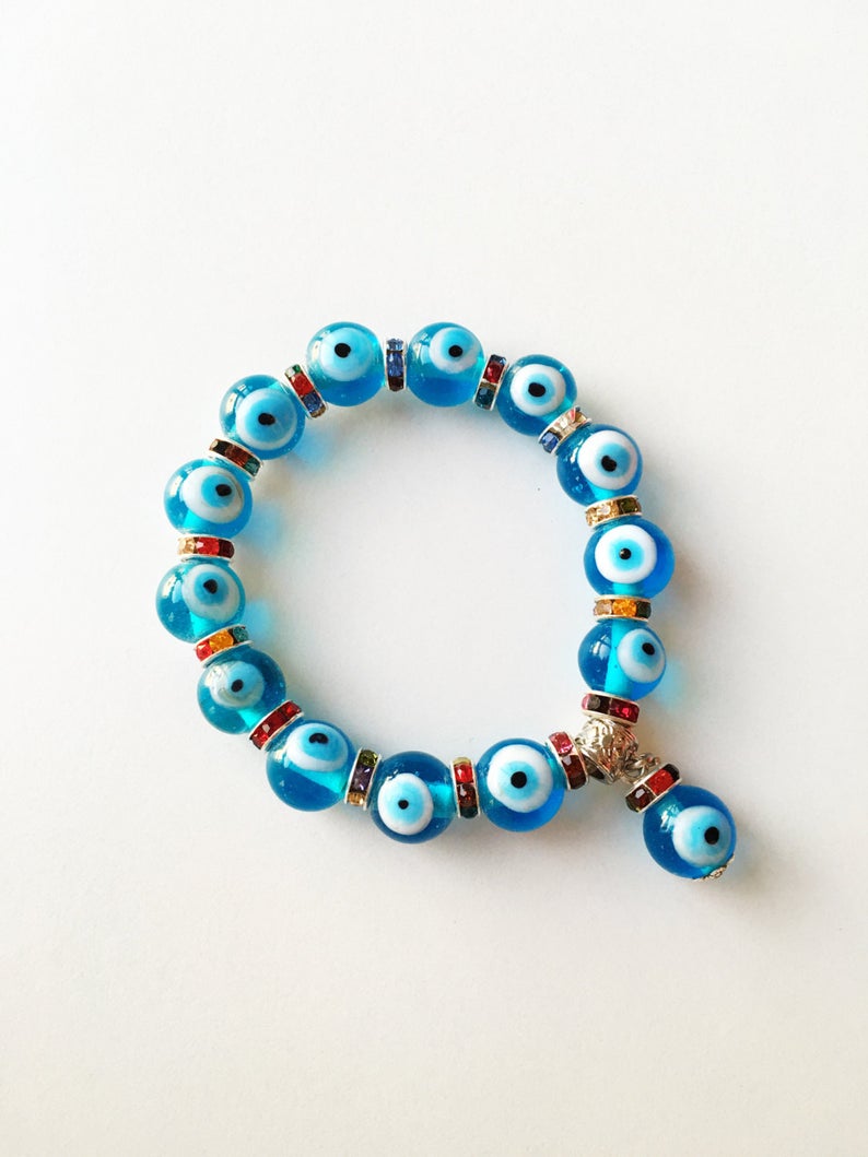 Evil Eye Stretch Bracelet featuring turquoise beads and a glass evil eye charm, symbolizing protection and good luck.