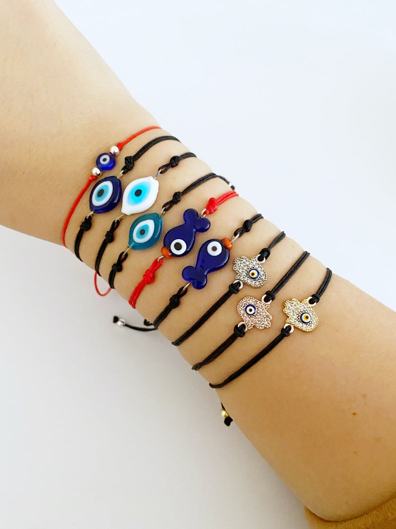 Evil Eye Thread Bracelet featuring a blue evil eye bead and adjustable string, adorned with a Hamsa charm.