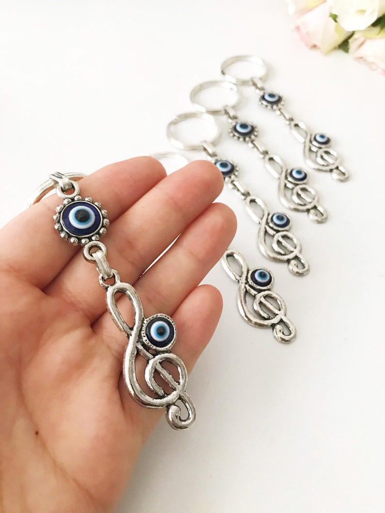 Evil Eye Treble Clef Keychain featuring a handmade blue glass charm and silver plated treble clef design.