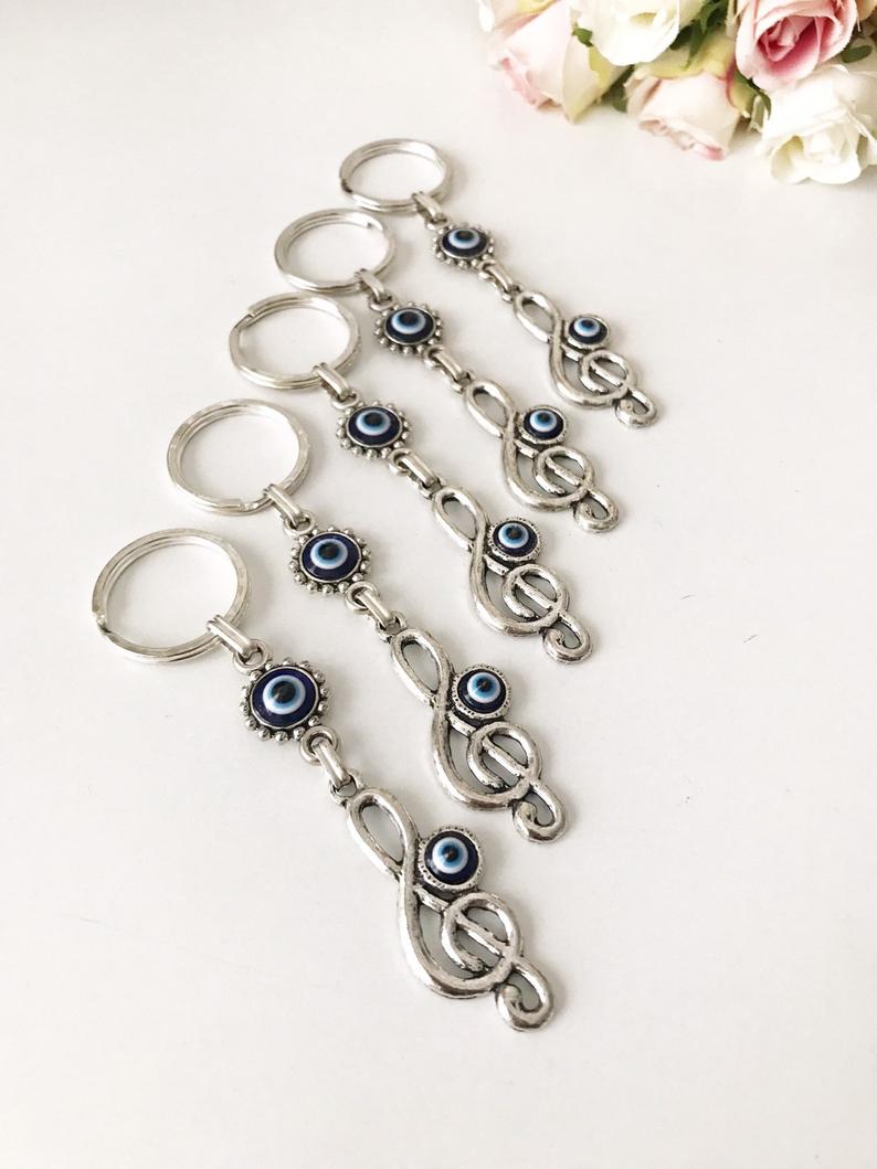 Evil Eye Treble Clef Keychain featuring a handmade blue glass charm and silver plated treble clef design.