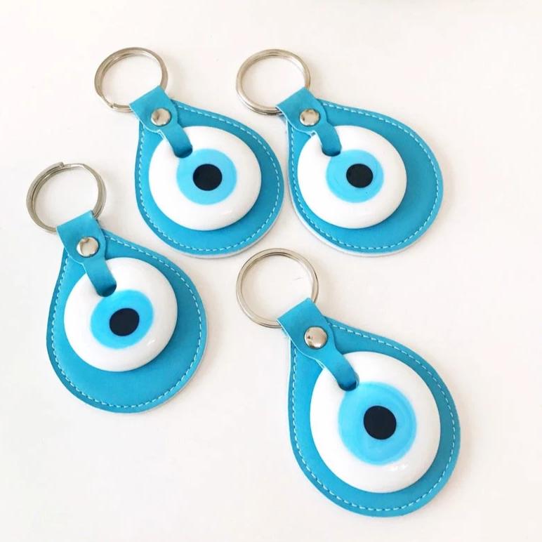 Evil eye turquoise leather keychain featuring a glass evil eye charm and durable leather strap, perfect for keys or as a bag charm.