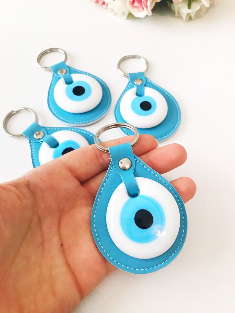 Evil eye turquoise leather keychain featuring a glass evil eye charm and durable leather strap, perfect for keys or as a bag charm.