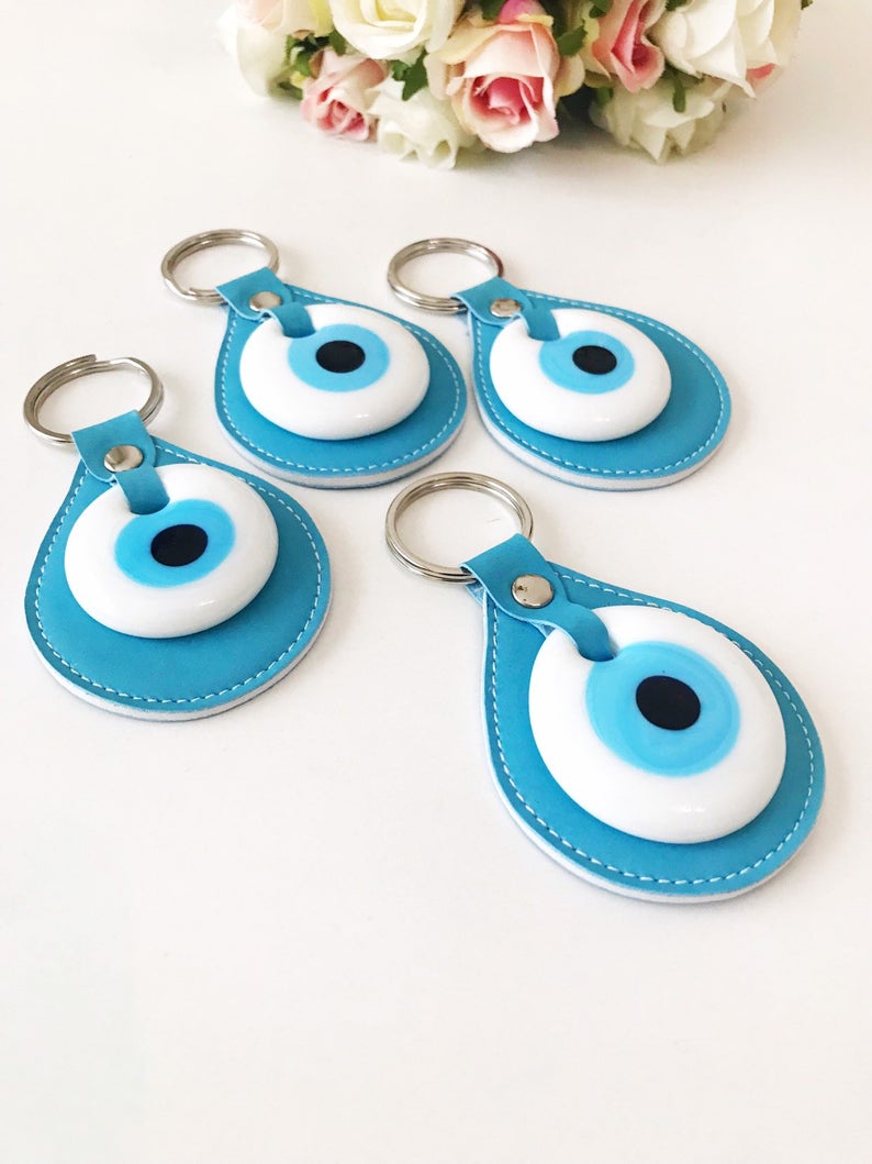 Evil eye turquoise leather keychain featuring a glass evil eye charm and durable leather strap, perfect for keys or as a bag charm.