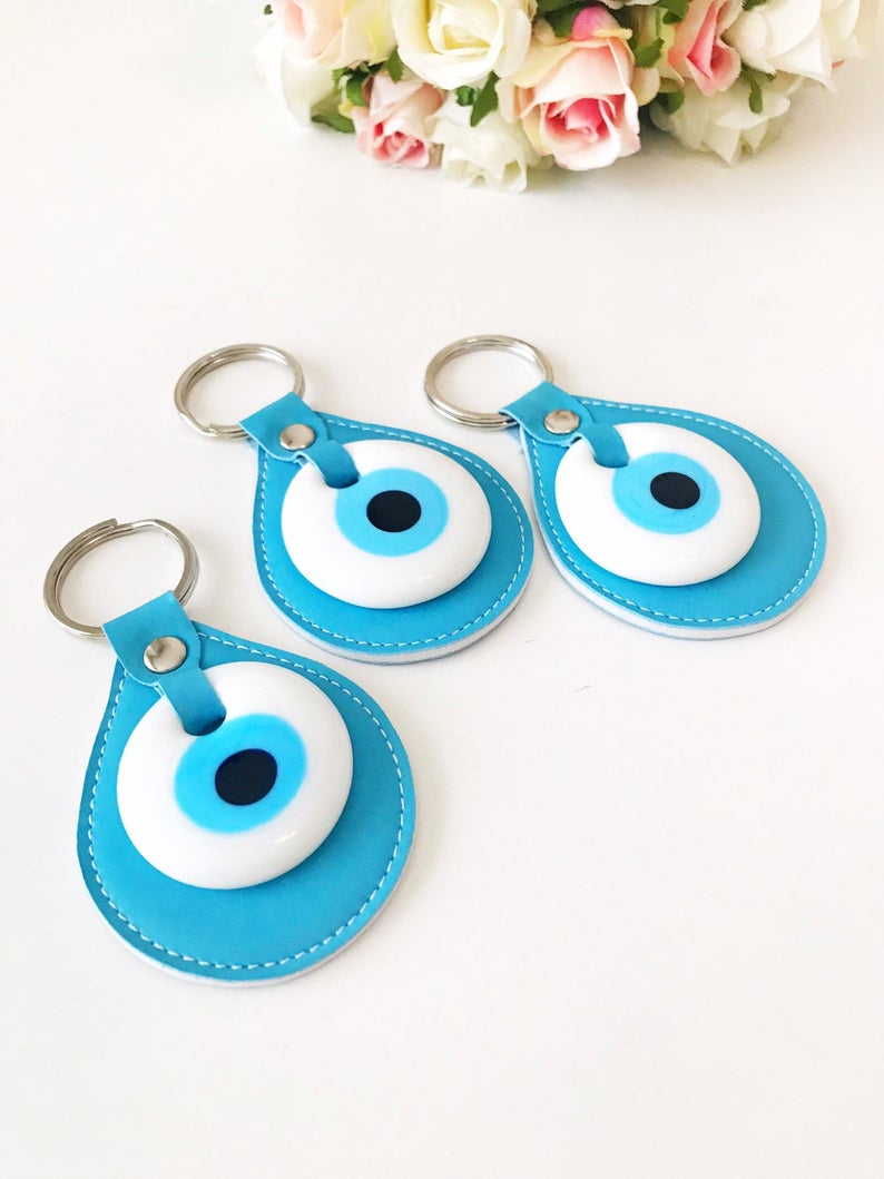 Evil eye turquoise leather keychain featuring a glass evil eye charm and durable leather strap, perfect for keys or as a bag charm.