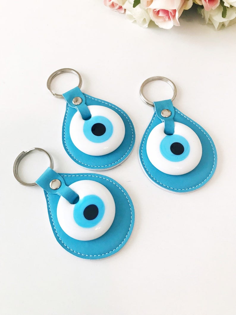 Evil eye turquoise leather keychain featuring a glass evil eye charm and durable leather strap, perfect for keys or as a bag charm.