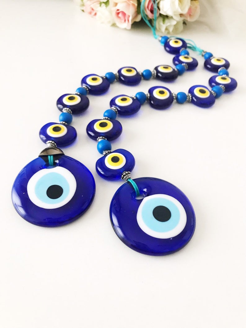 A beautifully crafted Evil Eye Wall Hanging featuring 8 beads, symbolizing protection and good fortune, perfect for home decor.