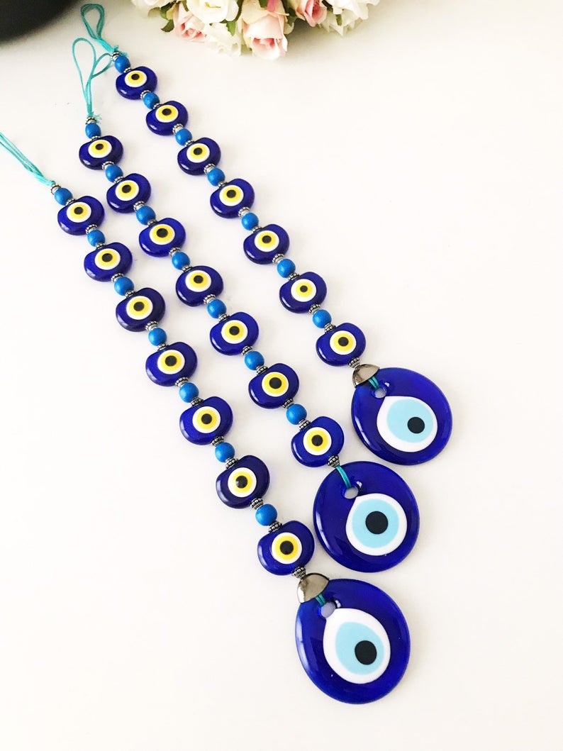 A beautifully crafted Evil Eye Wall Hanging featuring 8 beads, symbolizing protection and good fortune, perfect for home decor.