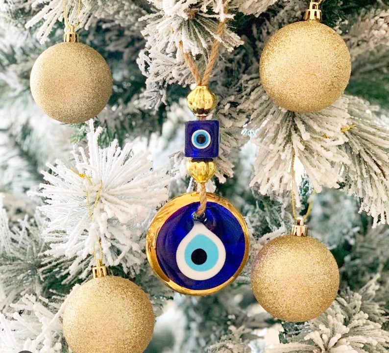 Handmade evil eye wall hanging with gold macrame and blue evil eye bead, perfect for home decoration and Christmas tree ornament.