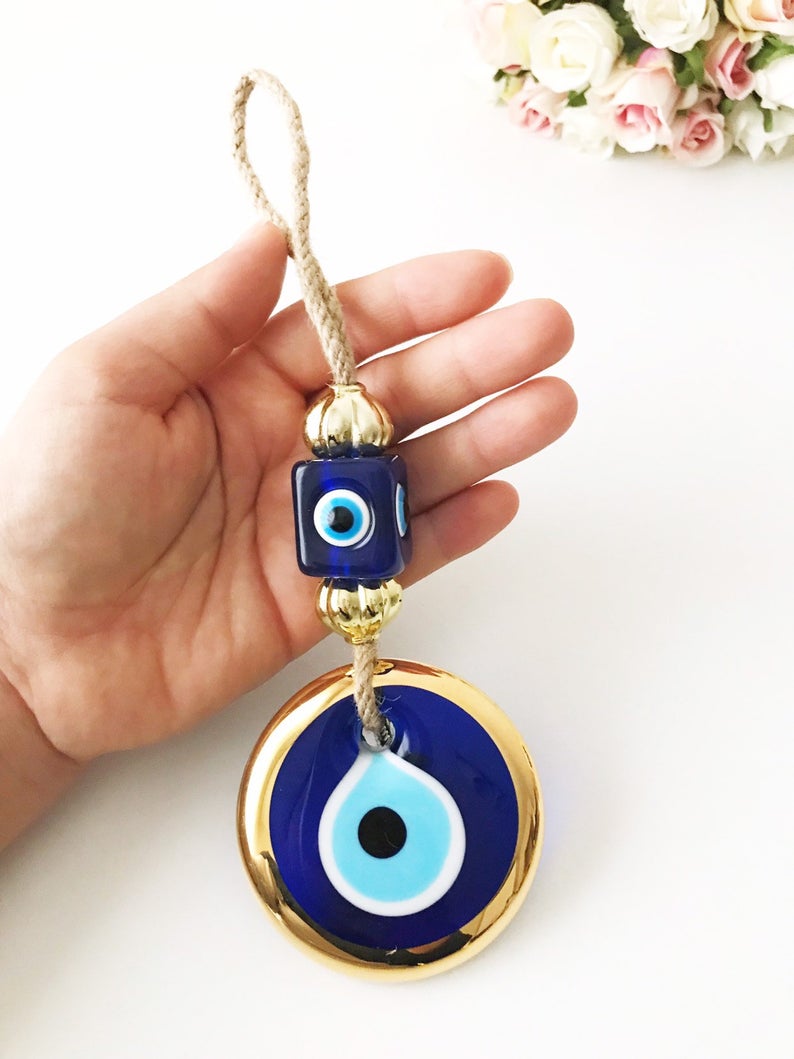 Handmade evil eye wall hanging with gold macrame and blue evil eye bead, perfect for home decoration and Christmas tree ornament.