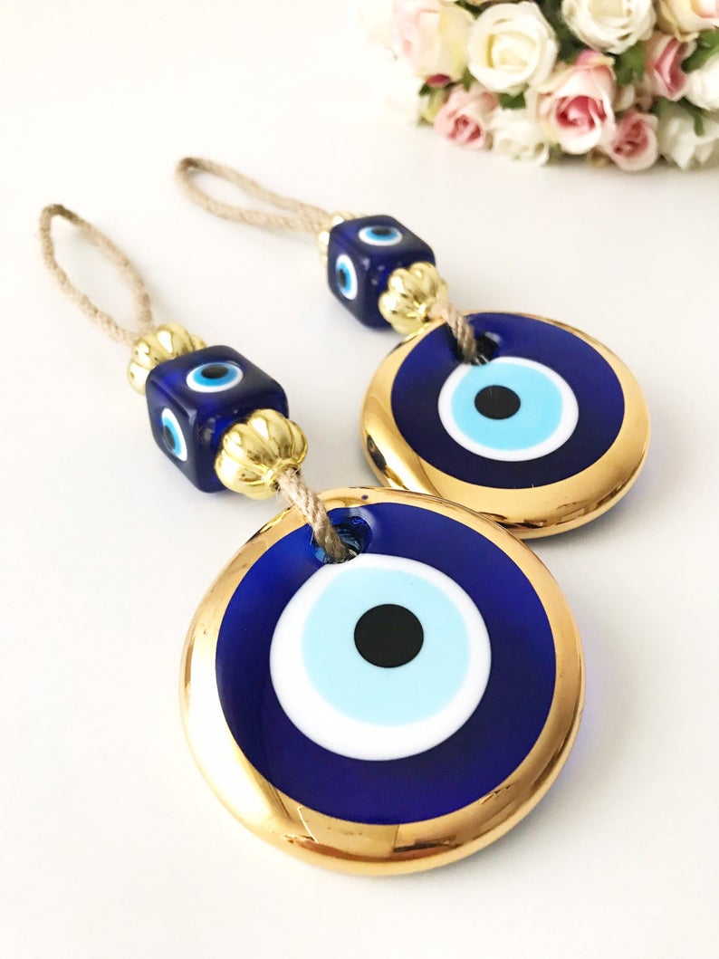 Handmade evil eye wall hanging with gold macrame and blue evil eye bead, perfect for home decoration and Christmas tree ornament.