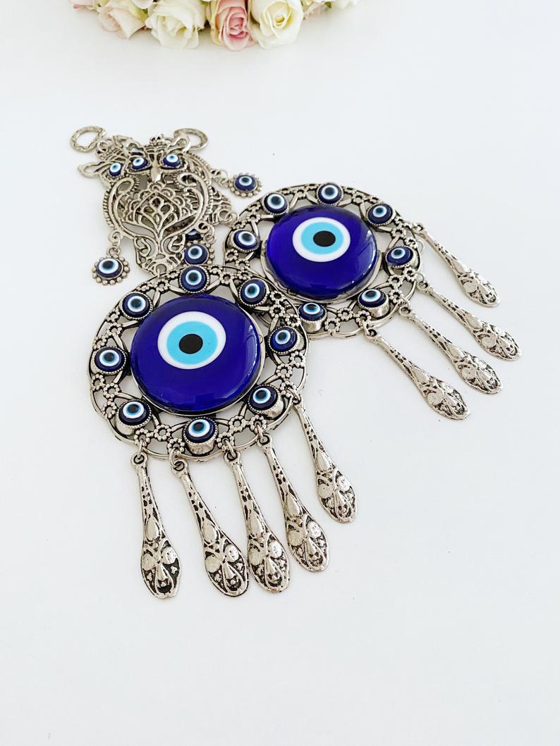 Handmade Evil Eye Wall Hanging featuring an owl charm, crafted with metal and glass beads, symbolizing good luck and protection.