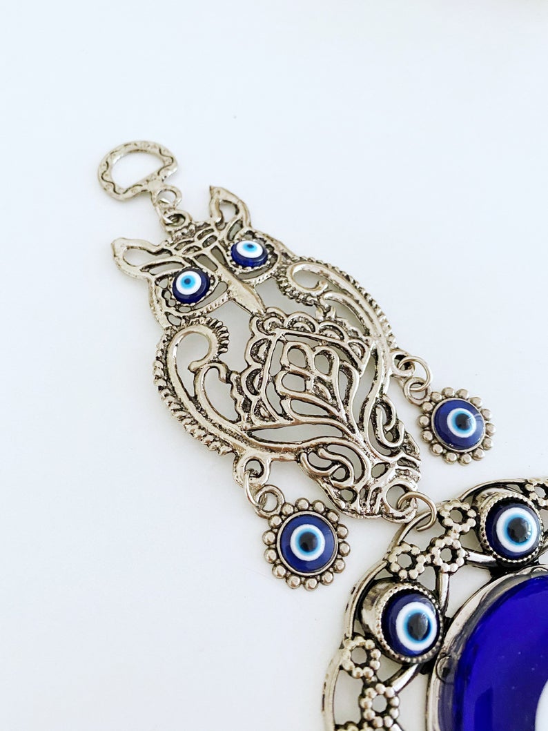 Handmade Evil Eye Wall Hanging featuring an owl charm, crafted with metal and glass beads, symbolizing good luck and protection.