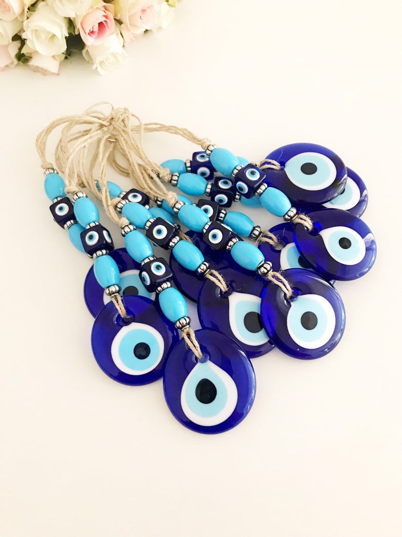 Handmade evil eye wall hanging featuring a large blue evil eye bead and turquoise beads, perfect for home decor and protection.