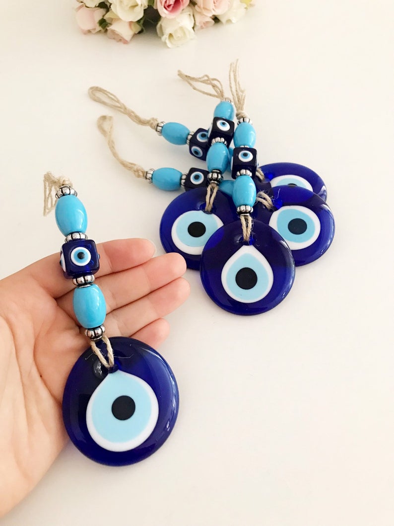 Handmade evil eye wall hanging featuring a large blue evil eye bead and turquoise beads, perfect for home decor and protection.