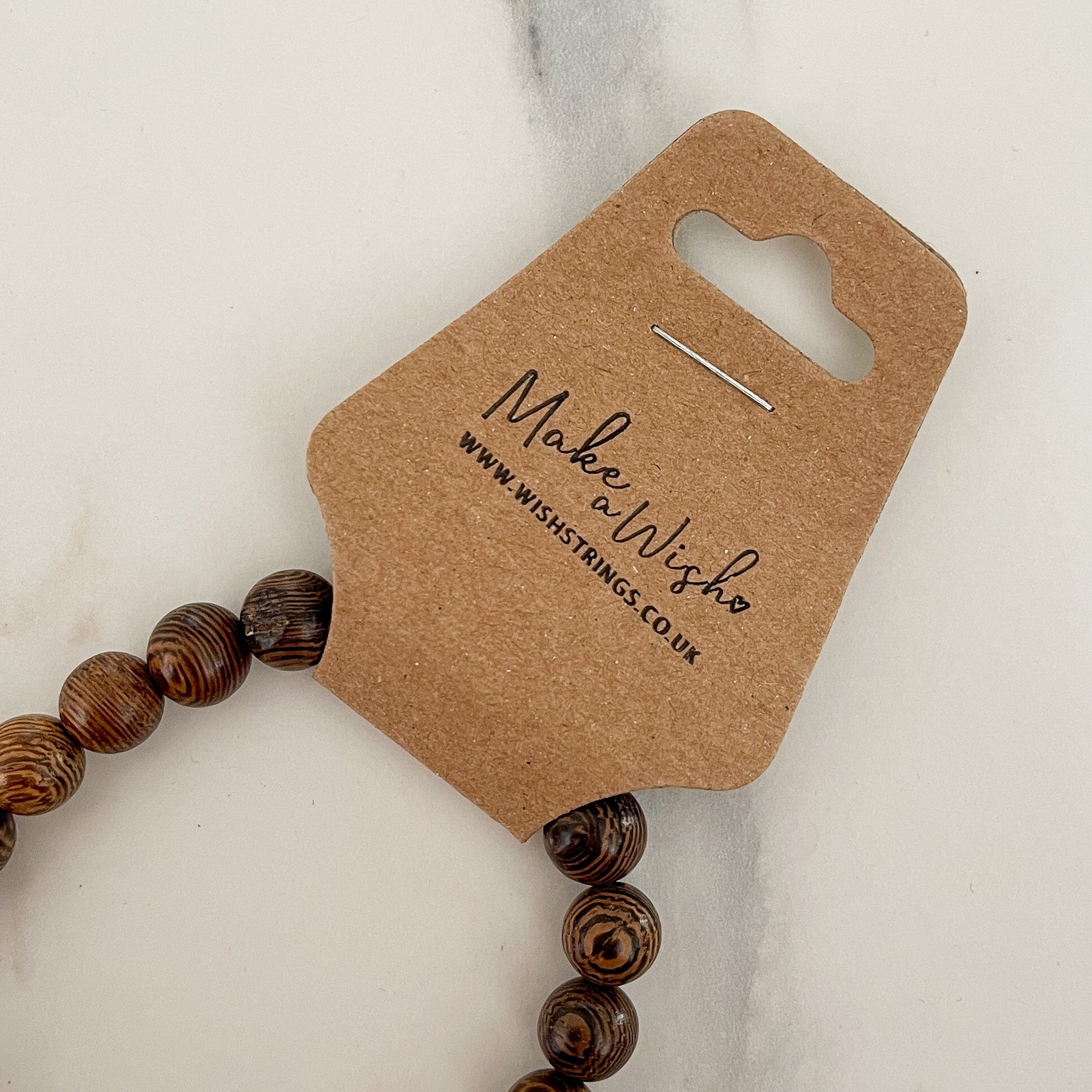 Family Tree Chakra Beaded Stretch Bracelet featuring colorful chakra beads on a brown kraft packaging tag.