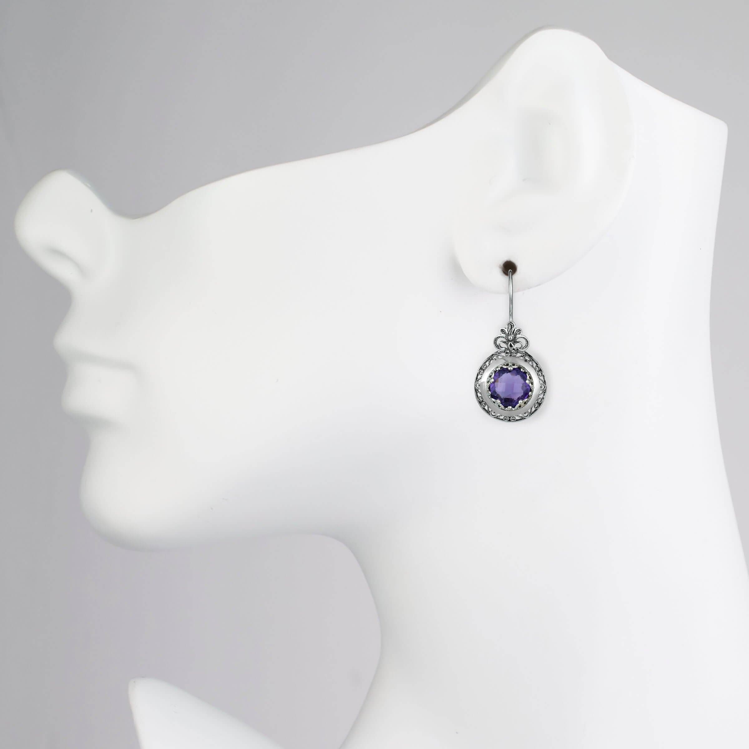 Handmade silver drop earrings featuring intricate filigree floral design and vibrant Amethyst gemstones, elegantly packaged.