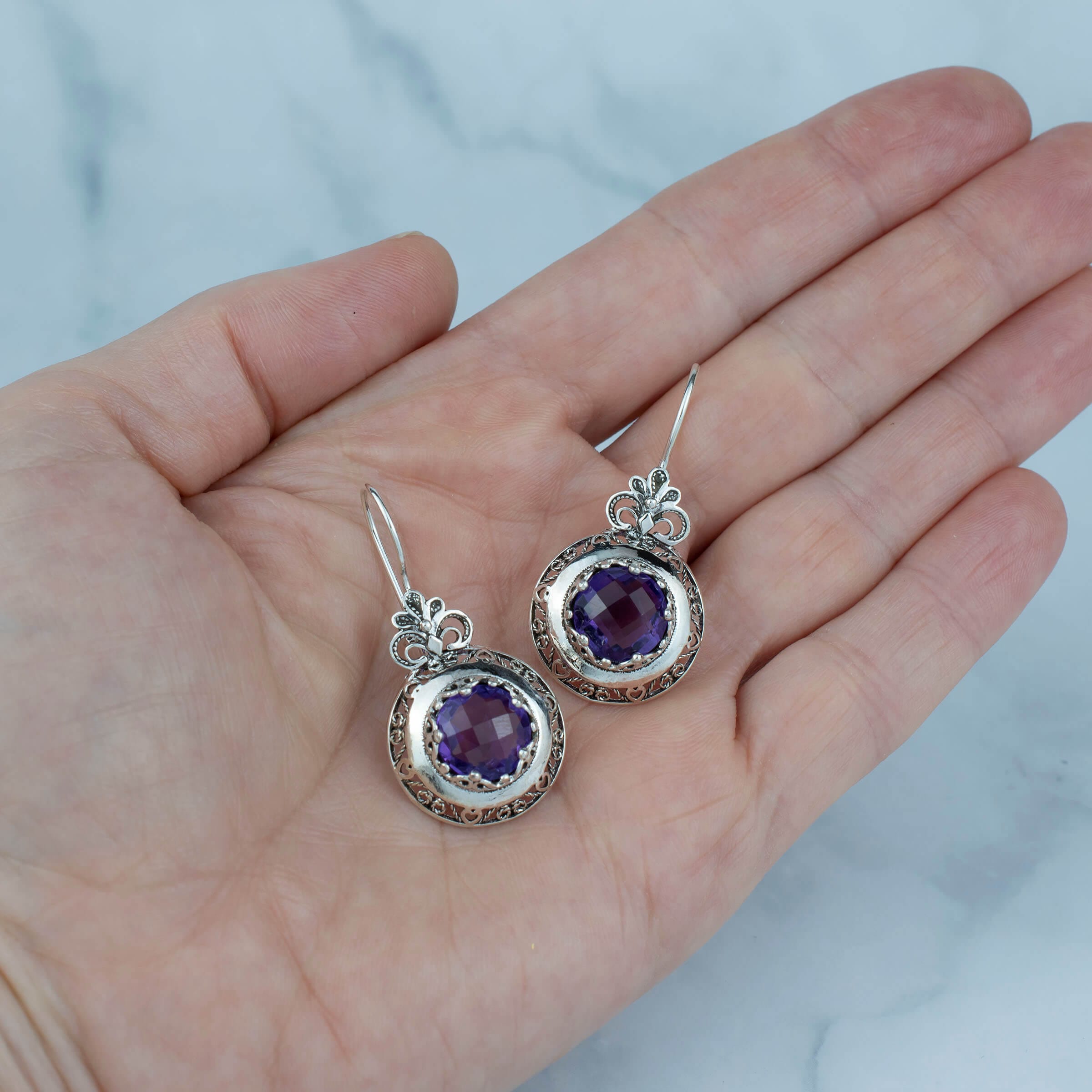 Handmade silver drop earrings featuring intricate filigree floral design and vibrant Amethyst gemstones, elegantly packaged.