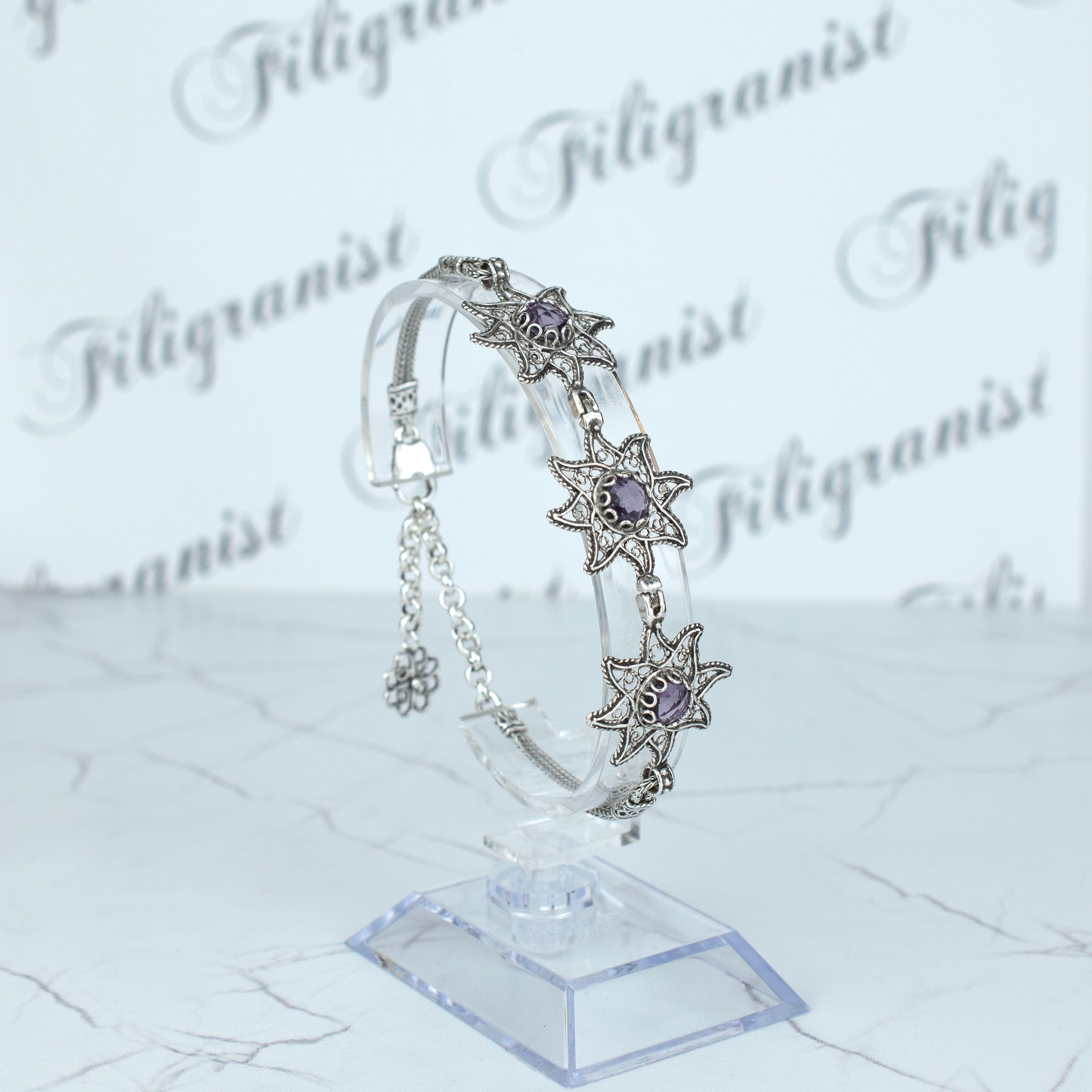 Sterling silver filigree bracelet featuring amethyst gemstones, showcasing intricate design and elegance.