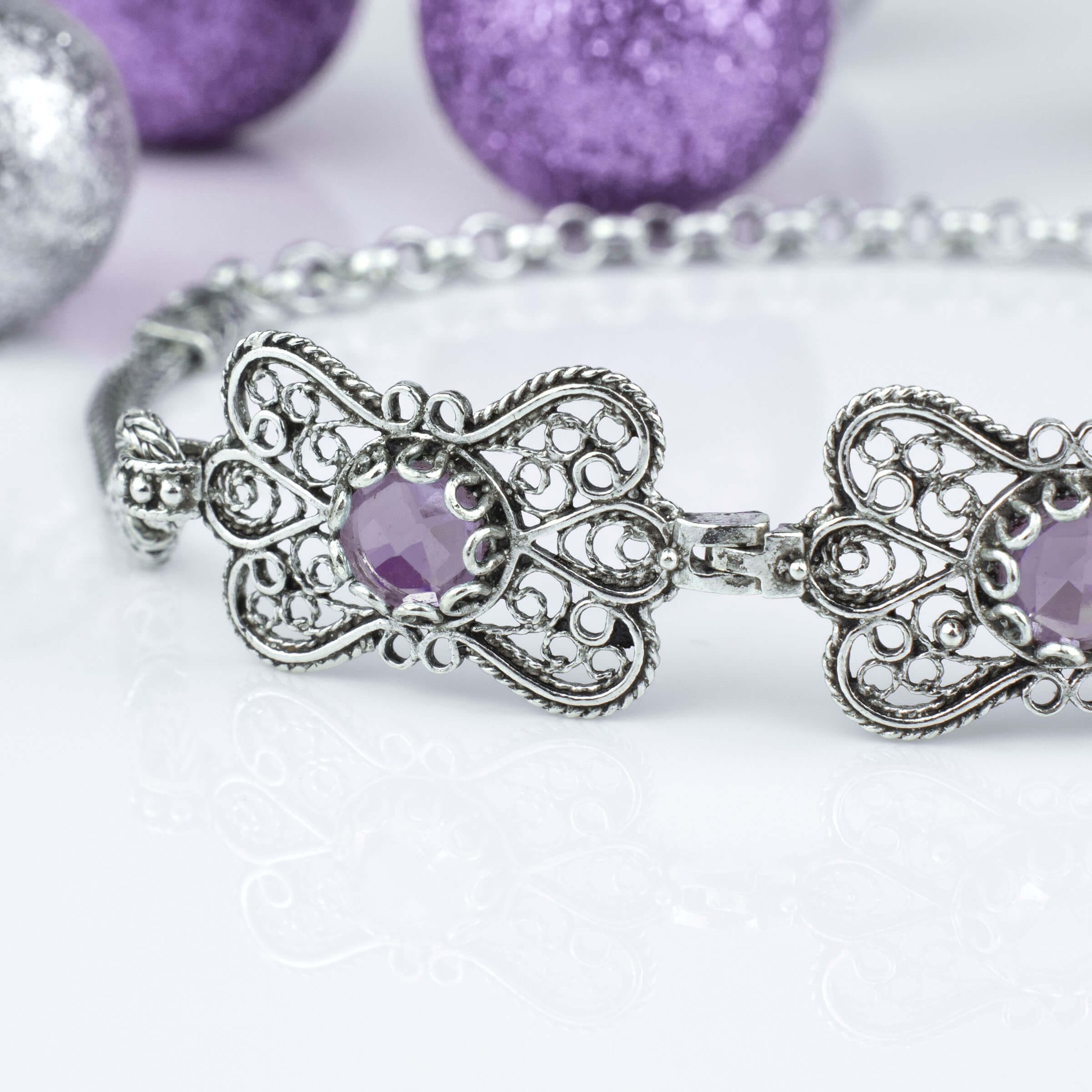 Sterling silver filigree butterfly bracelet featuring a faceted 6mm round amethyst gemstone, elegantly designed with intricate details.