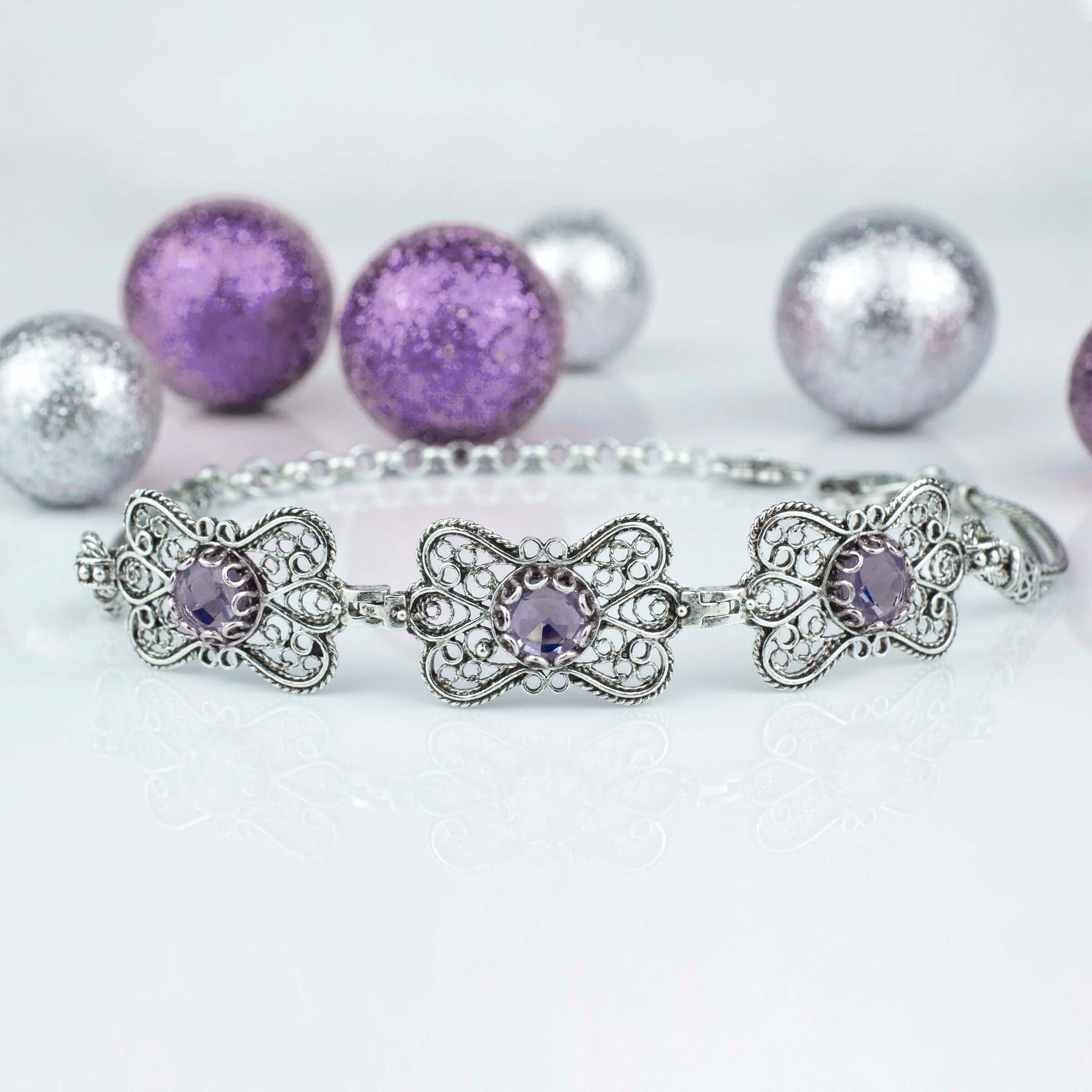 Sterling silver filigree butterfly bracelet featuring a faceted 6mm round amethyst gemstone, elegantly designed with intricate details.