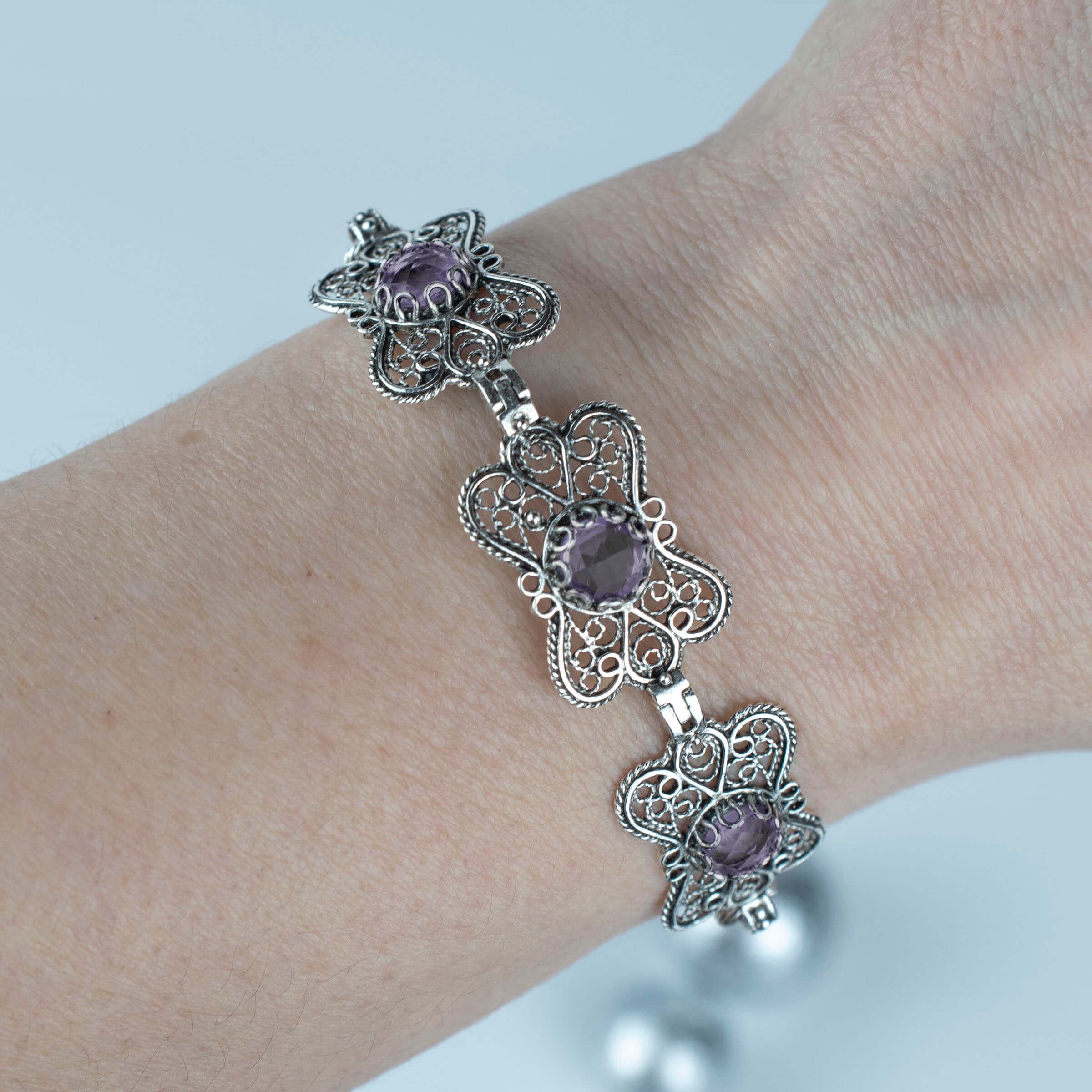 Sterling silver filigree butterfly bracelet featuring a faceted 6mm round amethyst gemstone, elegantly designed with intricate details.