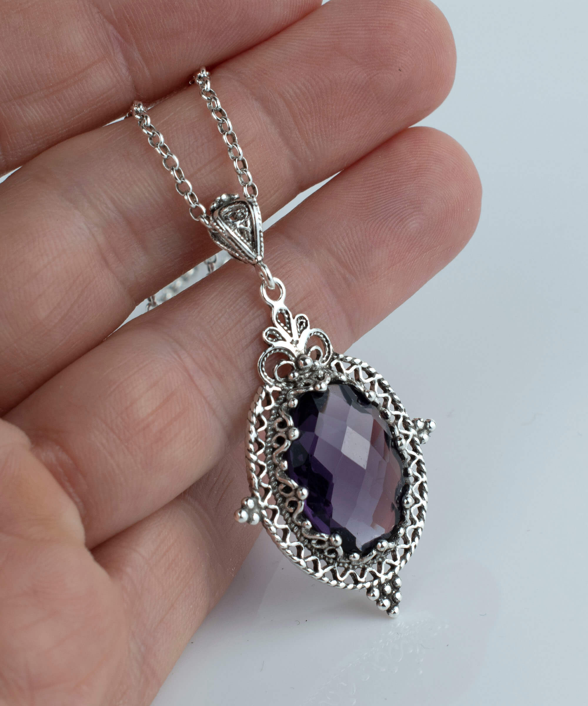 Elegant sterling silver filigree pendant necklace featuring a stunning amethyst gemstone in an oval shape, beautifully crafted for women.