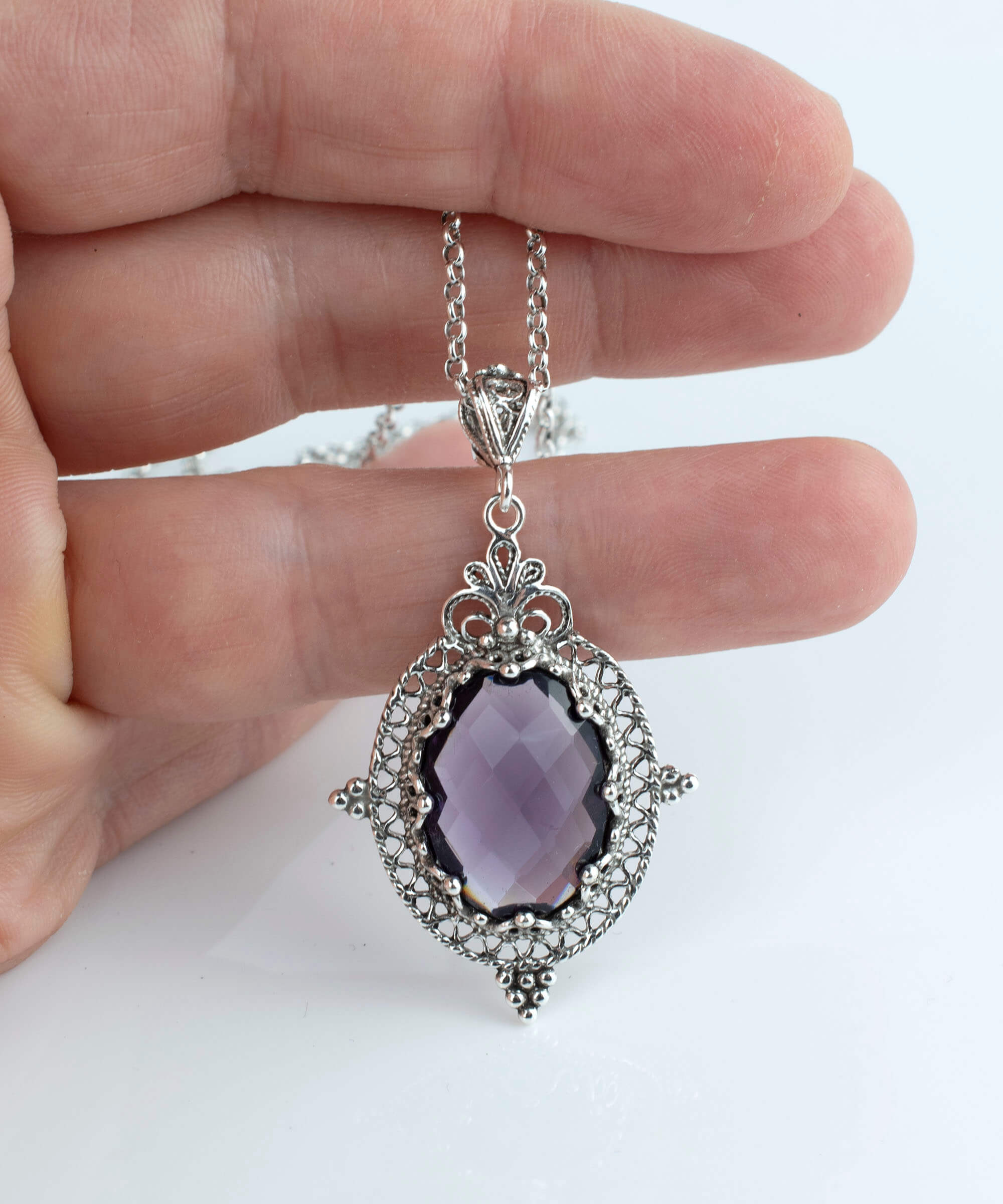 Elegant sterling silver filigree pendant necklace featuring a stunning amethyst gemstone in an oval shape, beautifully crafted for women.