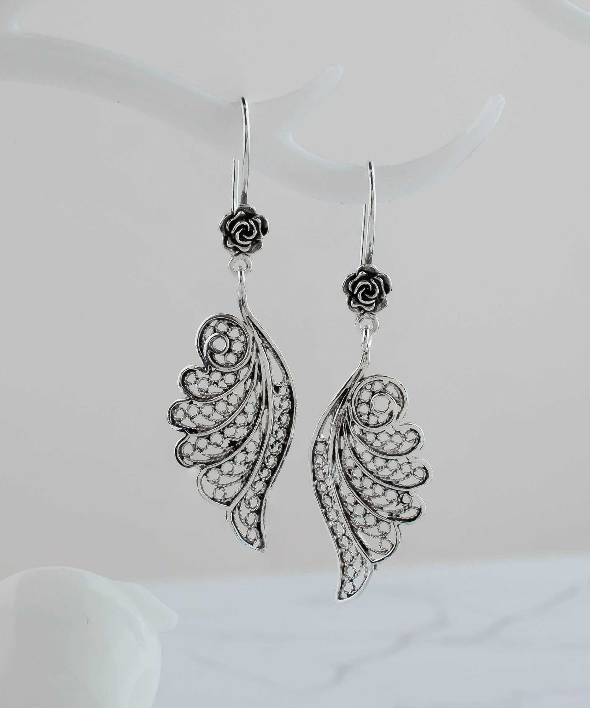 Elegant silver dangle drop earrings featuring intricate filigree angel wings design, handmade from high-quality 925 sterling silver.