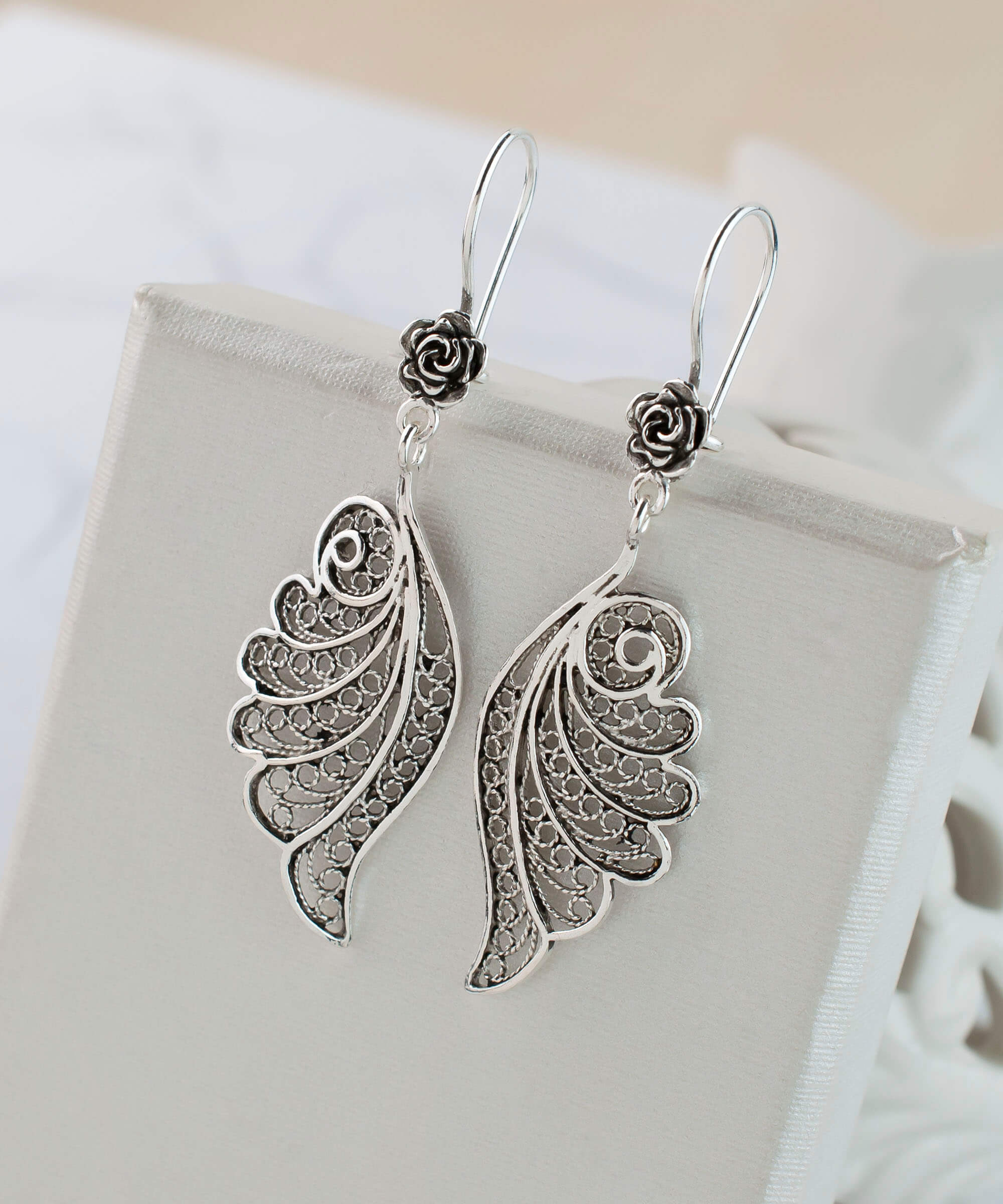 Elegant silver dangle drop earrings featuring intricate filigree angel wings design, handmade from high-quality 925 sterling silver.