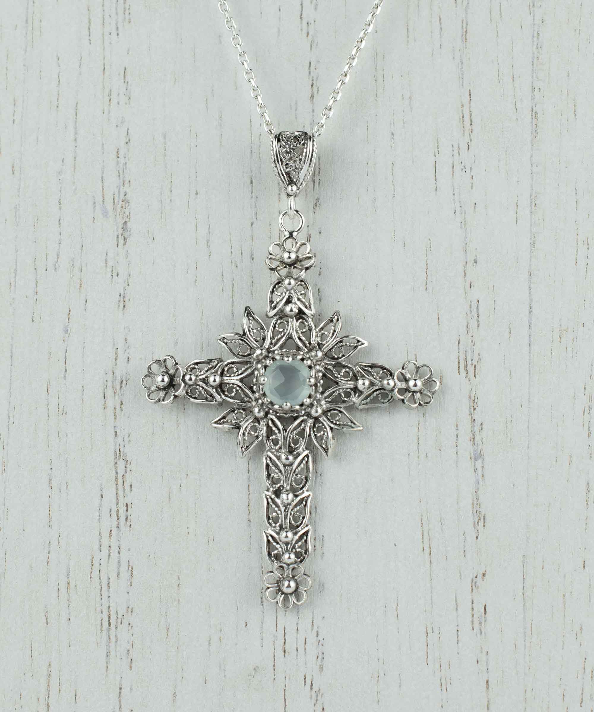 Handmade silver filigree cross pendant featuring Aqua Chalcedony gemstone, showcasing intricate details and elegant design.