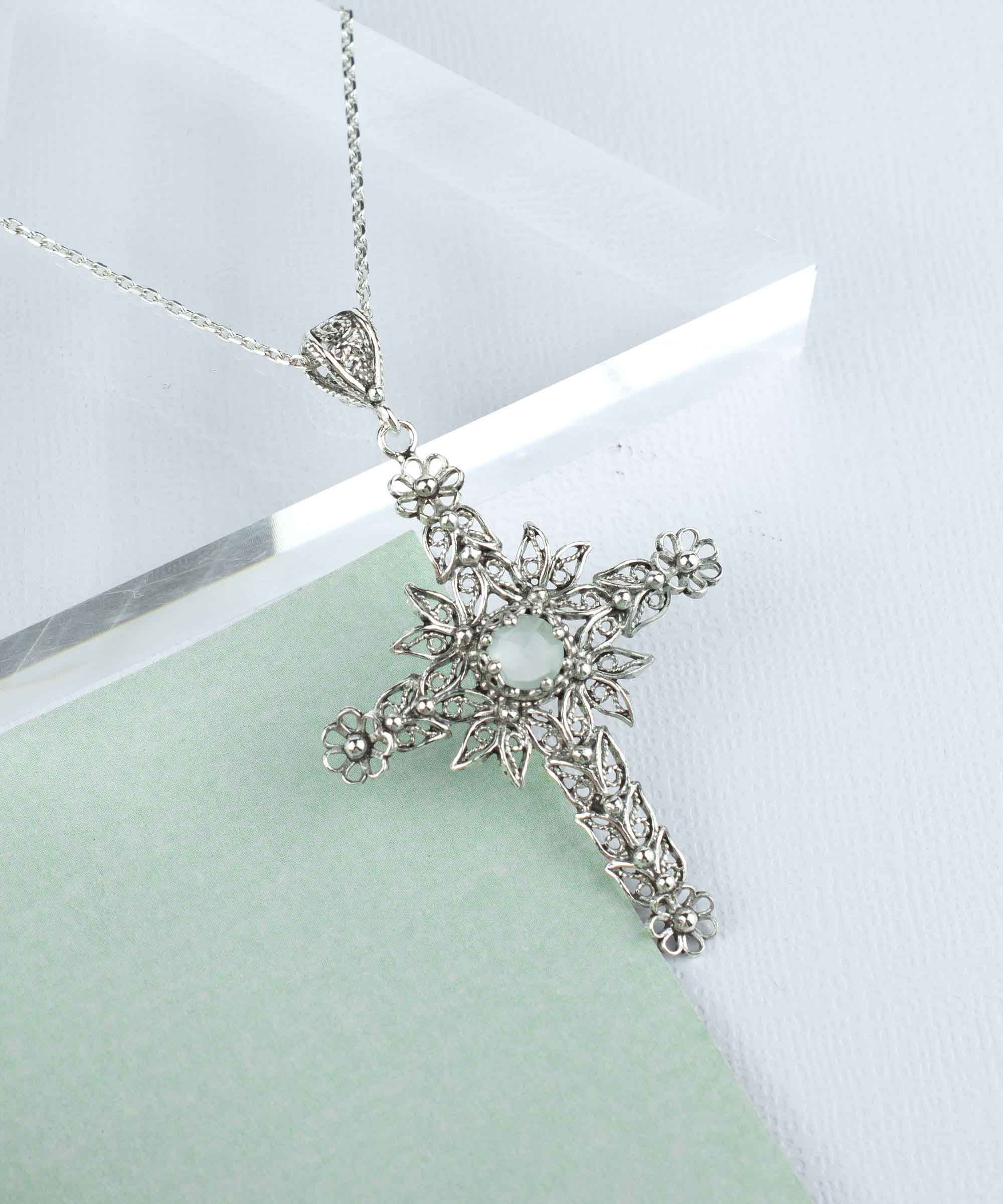 Handmade silver filigree cross pendant featuring Aqua Chalcedony gemstone, showcasing intricate details and elegant design.