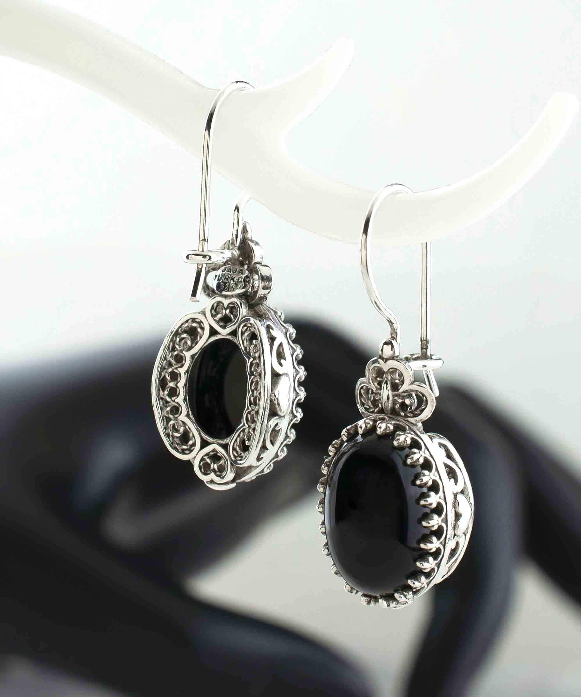 Elegant silver oval drop earrings featuring intricate filigree heart design and black onyx gemstone.