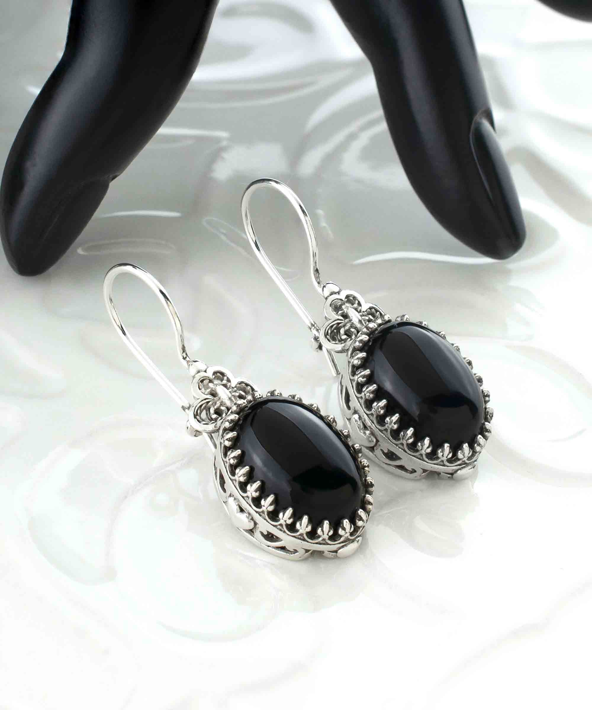 Elegant silver oval drop earrings featuring intricate filigree heart design and black onyx gemstone.