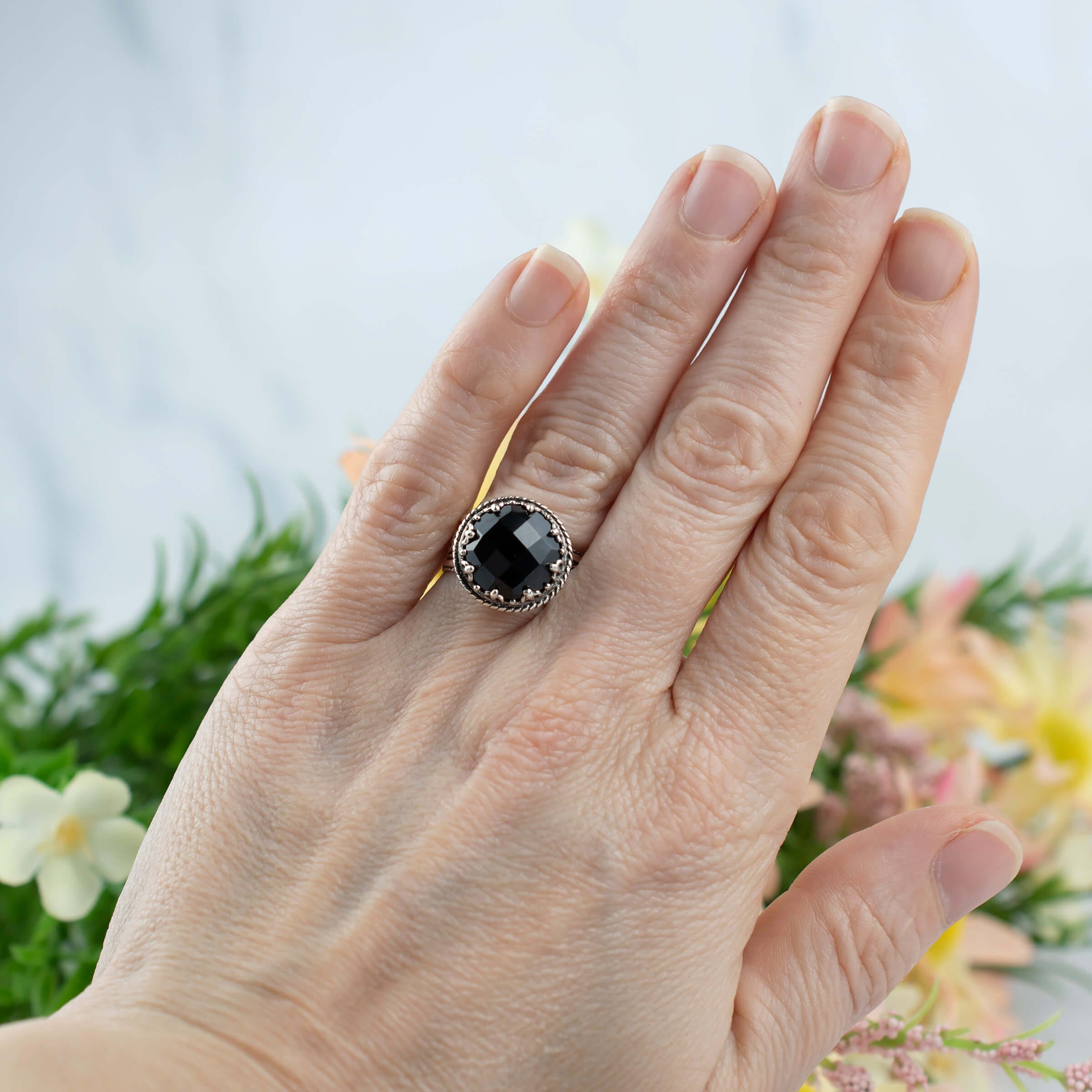 Elegant sterling silver cocktail ring featuring a black onyx gemstone with intricate filigree design.