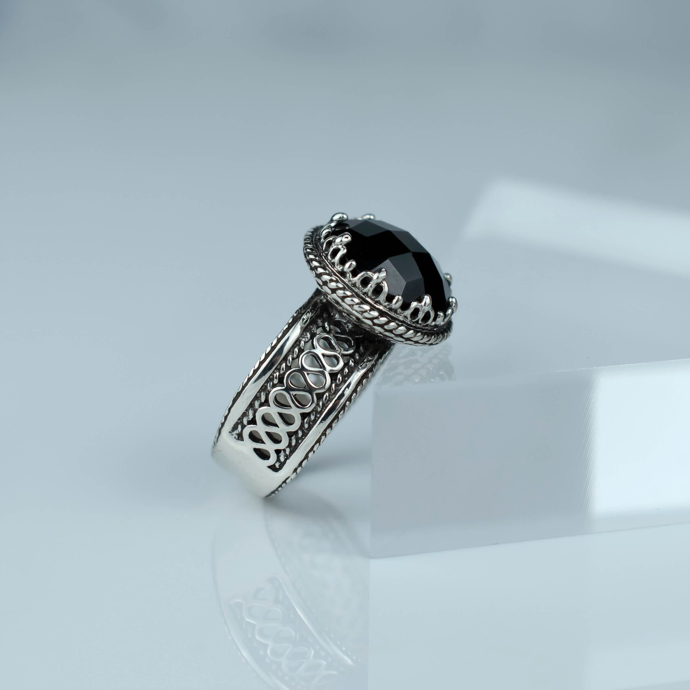 Elegant sterling silver cocktail ring featuring a black onyx gemstone with intricate filigree design.