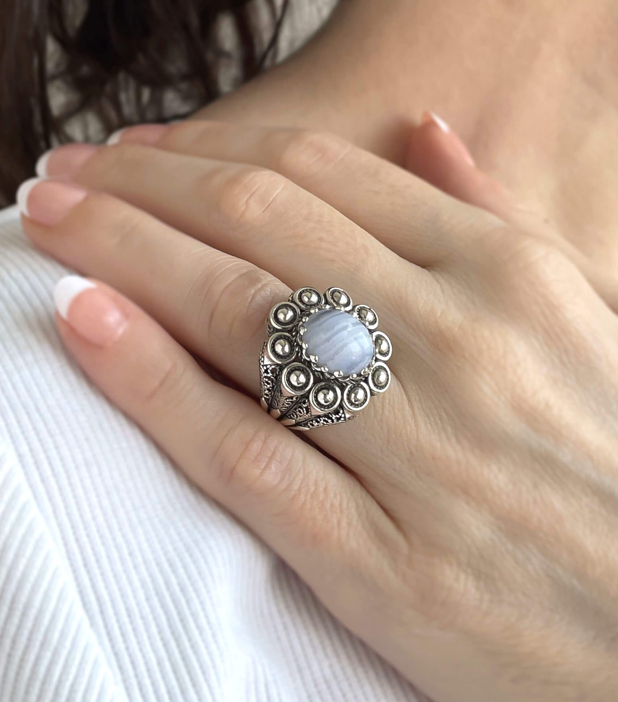 A handcrafted filigree art dome ring featuring a blue lace agate gemstone set in a 925 sterling silver band, showcasing intricate details and an antique finish.