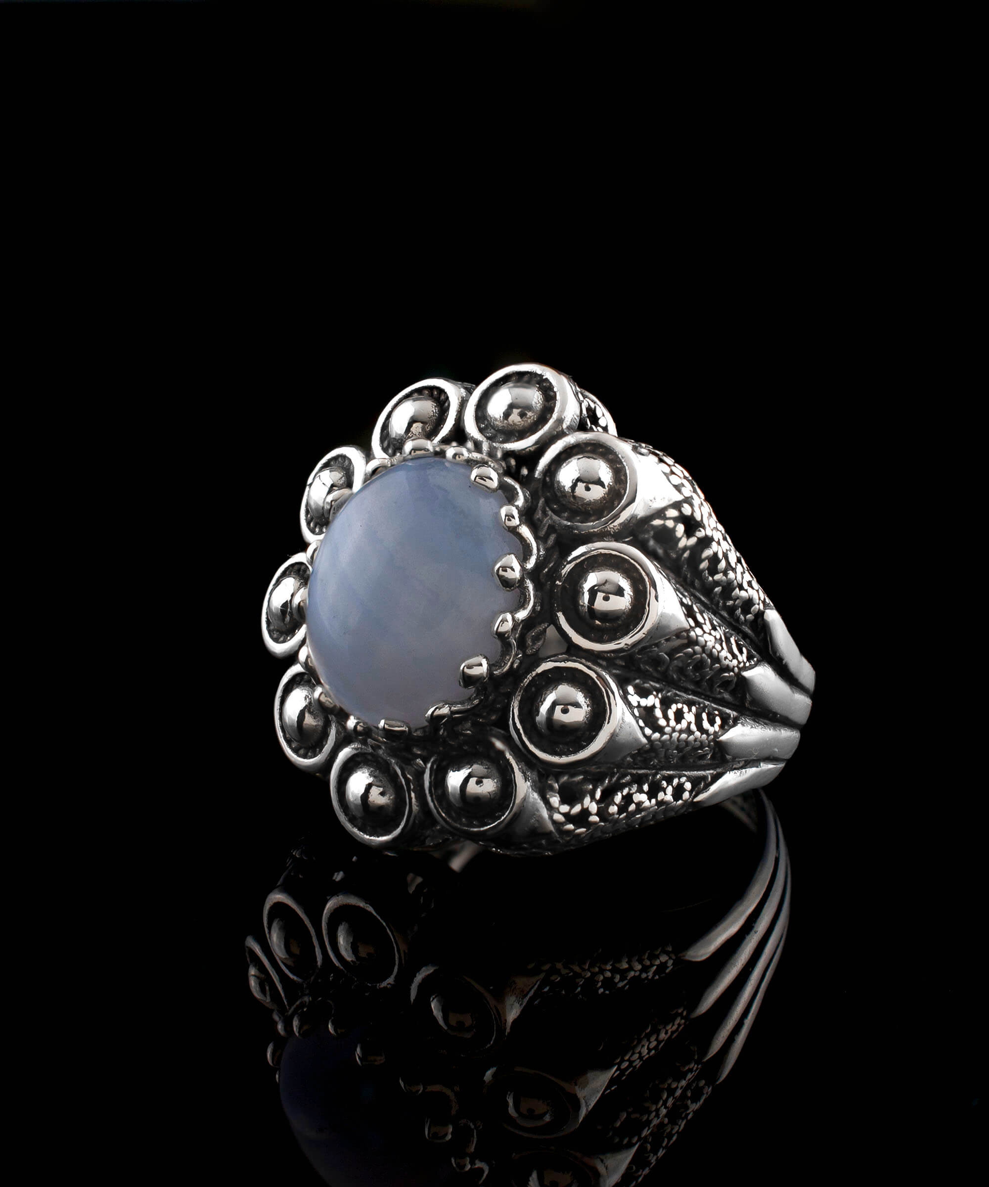 A handcrafted filigree art dome ring featuring a blue lace agate gemstone set in a 925 sterling silver band, showcasing intricate details and an antique finish.