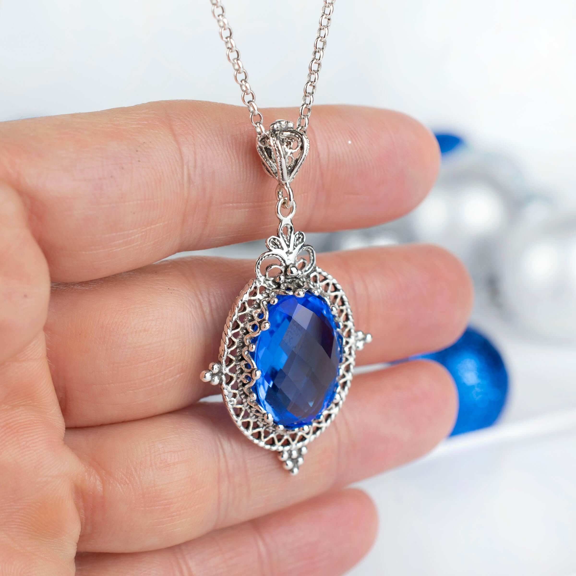 Sterling silver filigree art pendant necklace featuring a natural blue quartz gemstone, elegantly designed with intricate metalwork.