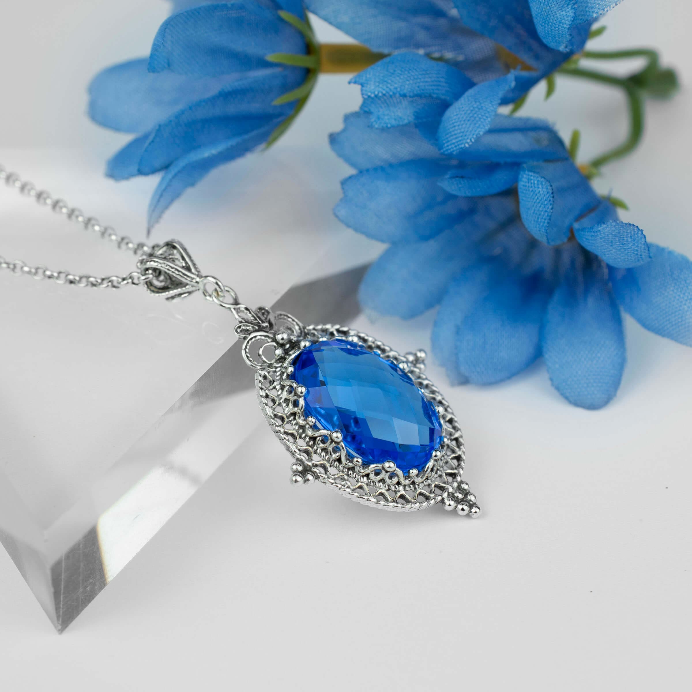 Sterling silver filigree art pendant necklace featuring a natural blue quartz gemstone, elegantly designed with intricate metalwork.