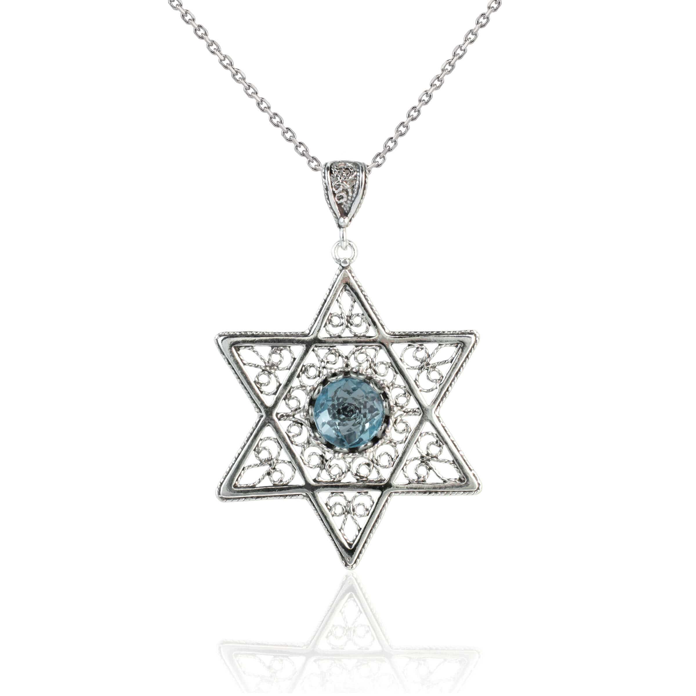 Sterling silver filigree pendant featuring a blue topaz gemstone in a Star of David design, showcasing intricate craftsmanship.