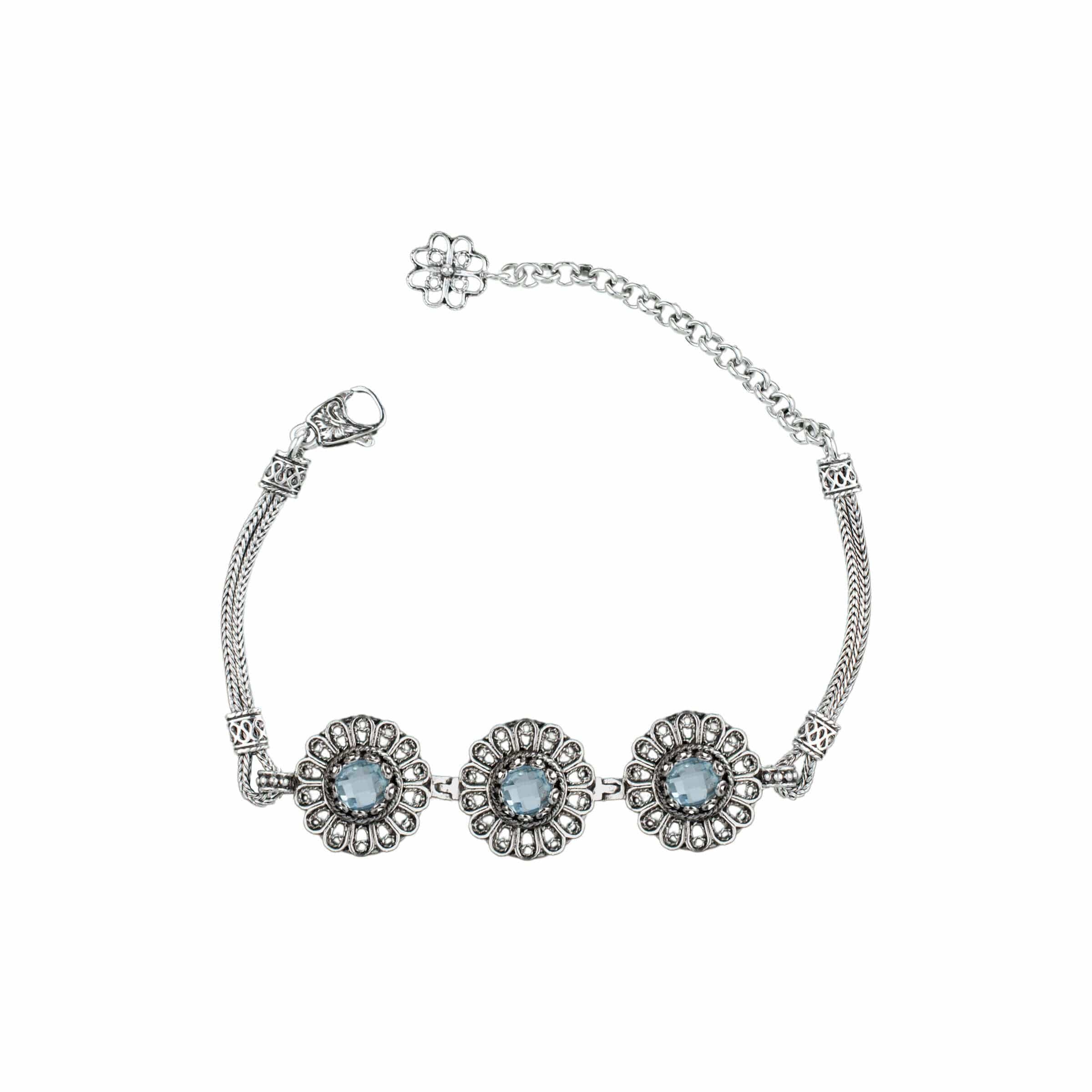 Elegant sterling silver link bracelet featuring intricate filigree art and a stunning sky blue topaz gemstone centerpiece.