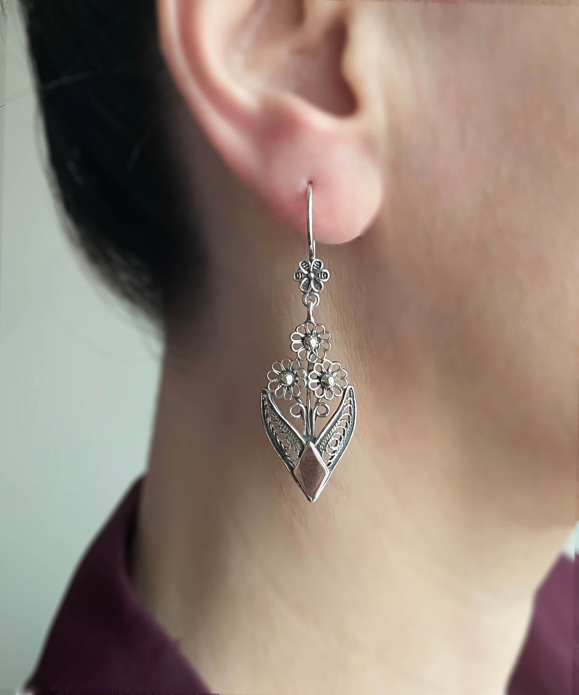 Handmade sterling silver dangle drop earrings featuring intricate filigree flower design, elegantly crafted for timeless beauty.