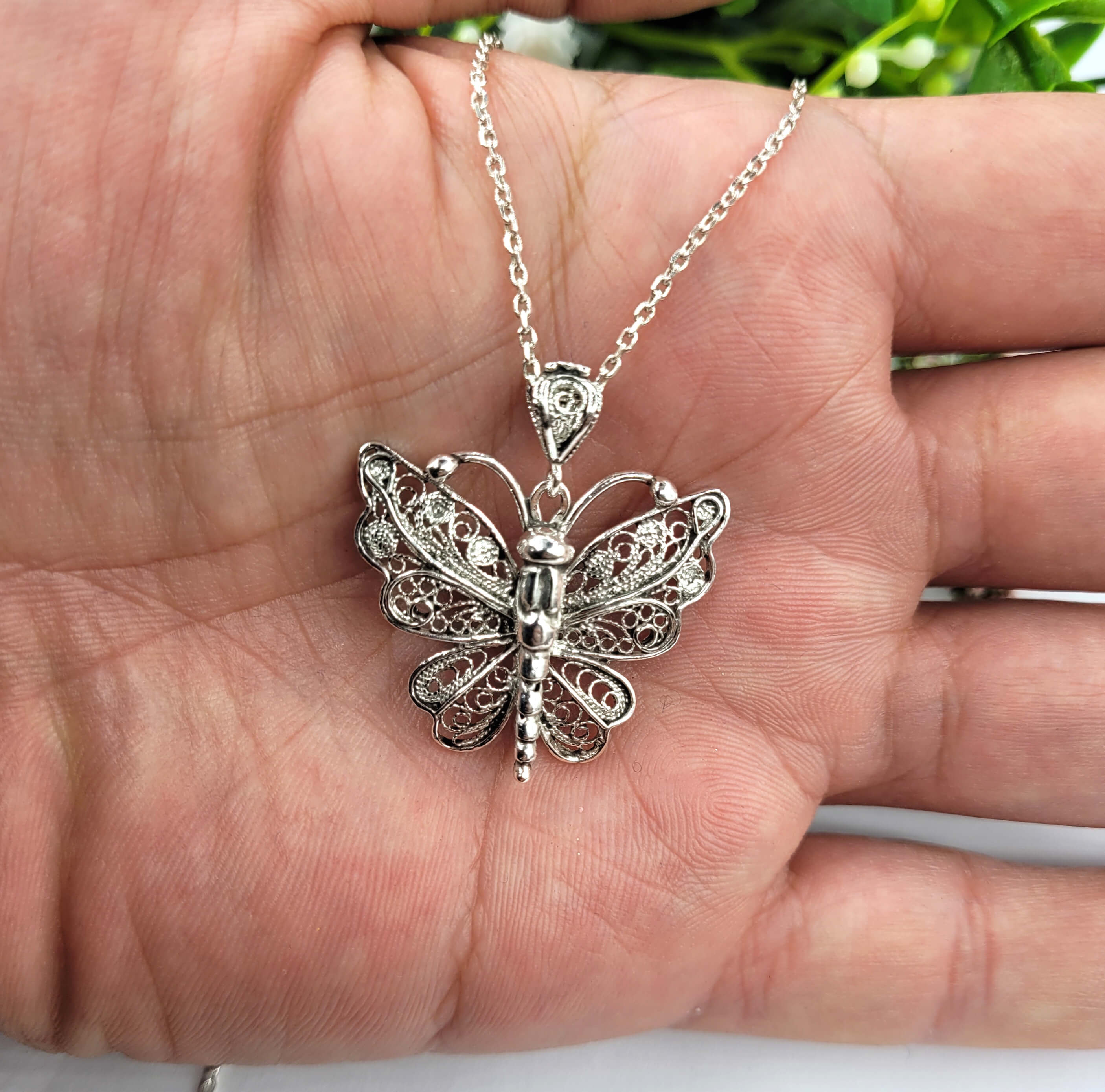 Sterling silver butterfly pendant necklace featuring intricate filigree design, displayed on a white background.