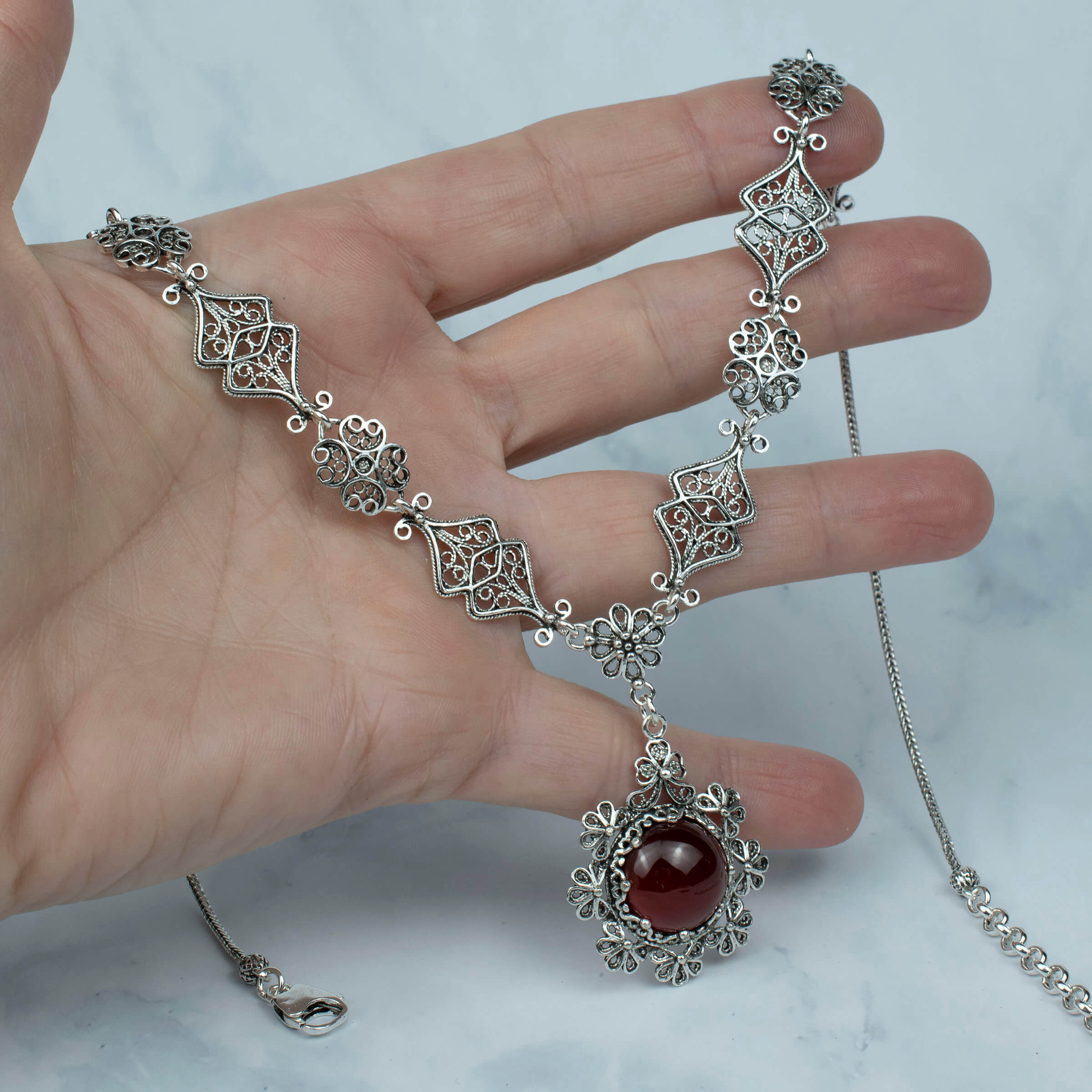 Elegant silver choker necklace featuring a round Carnelian gemstone centerpiece with intricate filigree design.